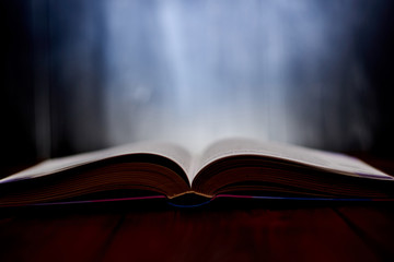 An open book with a glow in the background.