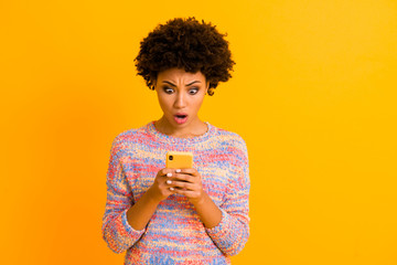 Portrait of crazy impressed afro american girl use cell phone read incredible bloggers social network information stare scream wow omg wear stylish outfit isolated shine color background