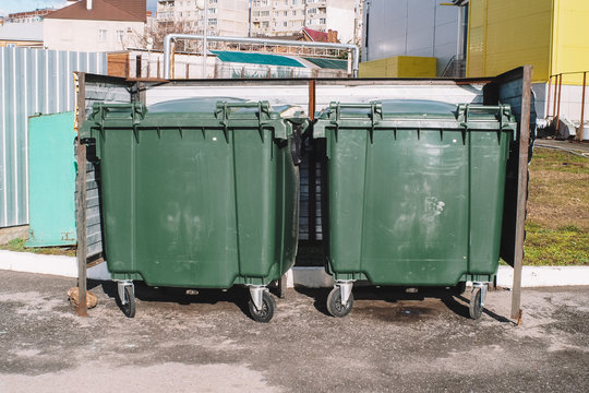 Modern garbage containers with garbage in a residential area. Environmental problem of processing and disposal of solid household waste in a big city. Concept of environmental pollution