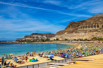 sunny landscape with the picturesque colorful Amadores beach on the Spanish Canary Island of Gran Canaria