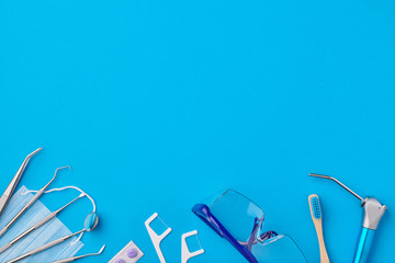 Dentist tools over blue background top view