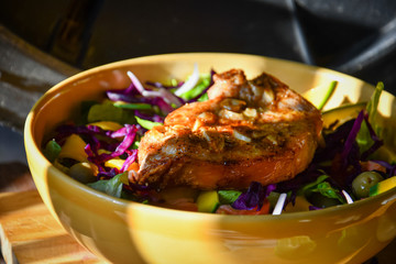 Big bowl of fresh colored Salad with fried pork chop.