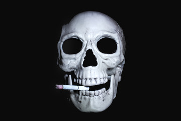  Human skull with a smoking cigarette in his mouth looking out of the dark