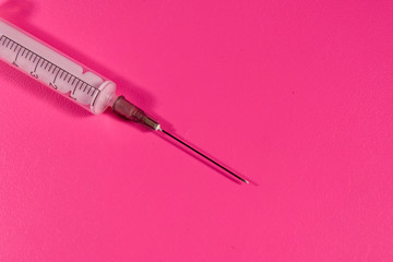 Syringe on a pink background. Healthcare and medicine concept