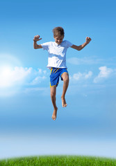 A boy jumps on a summer background of blue sky