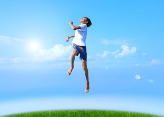 Fototapeta na wymiar A boy jumps on a summer background of blue sky