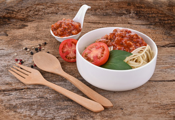 Pasta with tomato sauce and basil on wooden background