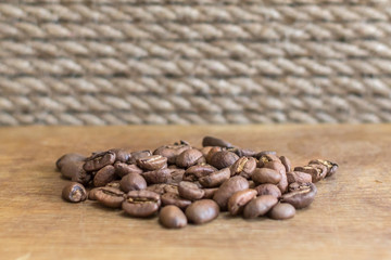 A handful of coffee beans. Grade Arabica. Hot coffee drink. Strong espresso. Grains of medium frying. The menu in the coffee shop. Fragrant drink. Coffee bean close-up. An invigorating morning drink.