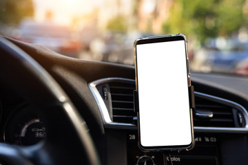 Modern smartphone device gadget mounted on phone holder at car dashboard. Mock-up white screen...