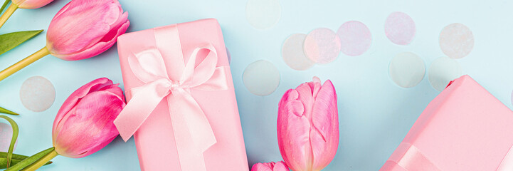 View from above tulips and gift box with copy space on blue. Background for womens day, 8 March Valentines day, 14 february. Flat lay style, top view, mockup, template, overhead. Greeting card