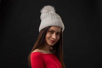 woman modern hipster portrait smiling happy and confident looking at camera on black background wearing knit hat.