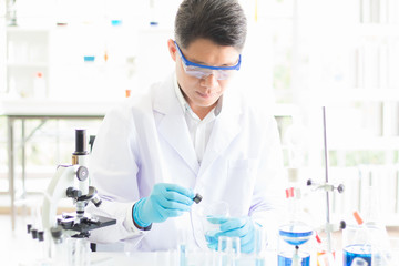 Fototapeta premium An Asian male virology scientist is conducting a vaccine to prevent and treat a new type of corona virus 2019 coming from Wuhan, China in the morning lab.