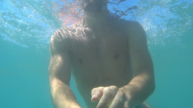 A video filmed underwater that shows a guy diving and swimming underwater 