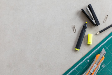 stationary and office equipment on cement table background. top view