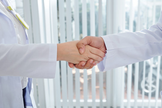 Close-up image of medical workers shaking hands when meeting in hospital