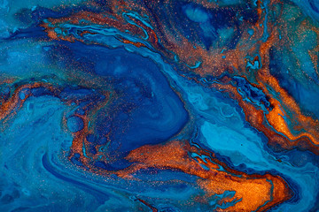Fluid art texture. Background with abstract swirling paint effect. Liquid acrylic picture with flows and splashes. Mixed paints for posters or wallpapers. Blue, orange and golden overflowing colors