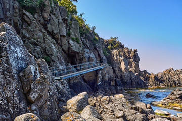Footbridge leading to Sorte gryde (Black pot) sea cave located at the base of the cliff of...
