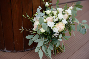 Close up of lush wedding bouquet of white flowers and greenery on wood background, copy space. Bridal bouquet