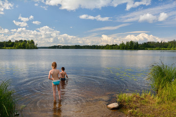 Fototapeta na wymiar little girl and boy swimming in summer lake