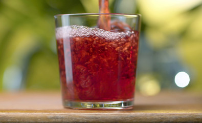 Red juice pouring into the glass