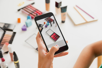 Female taking photos of makeup products