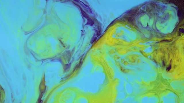 Fluid art. Abstract acrylic textures with flowing effect. Fancy fluid surface drawing. Abstract background footage with acrylic flow animation, close up view. Yellow, green and blue paint motion