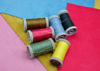 colorful spools of thread on fabric background