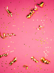 Golden decorations and sparkles on pink background