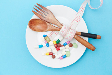 Diet pills and scales on the plate