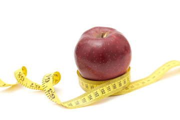 Red apples on the table and a ruler for measuring waistline