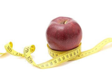 Red apples on the table and a ruler for measuring waistline