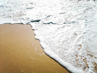 Golden sand and water on the seashore as a background