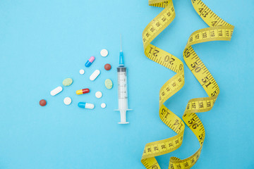 Diet pills, syringes, rulers and other weight-loss materials placed on the table