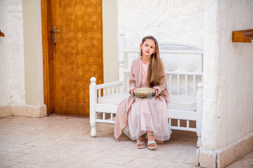 girl in a dress sitting on chair