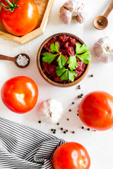 Homemade tomato sause near ingredients - garlic, spices - on white background top-down