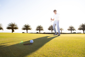 Professinal golf player on golf course. Pro golfer taking a shot