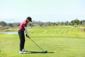 Professinal golf player on golf course. Pro golfer taking a shot