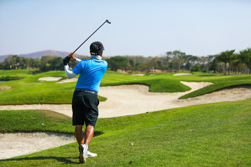 Professinal golf player on golf course. Pro golfer taking a shot