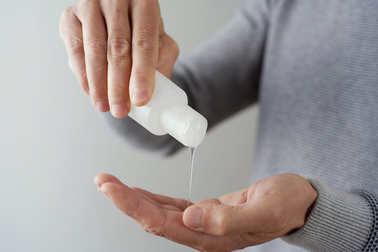 man disinfecting his hands with hand sanitizer.