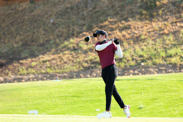 Professinal golf player on golf course. Pro golfer taking a shot