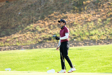 Professinal golf player on golf course. Pro golfer taking a shot