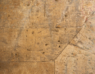wall of yellow rectangular stones with cement, fragment of ancient architecture