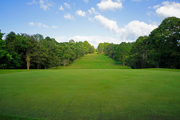 The evening golf course has sunlight shining down at golf course in Thailand