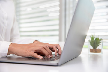 A business woman sitting in front of a laptop in the office.Data analysis concept from summary graph statistics for business meeting executives. Graph, statistics, financial, management, accounting.