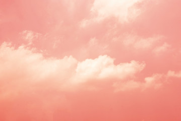 White clouds against the pink sky against a blurred patterned background