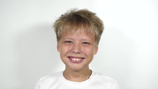 Closeup view 4k video portrait of smiling happy cute funny white kid. Teeth with overbite need braces correction.
