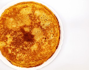 Round, thin, fresh pancakes on a white plate. Pancakes with sunflower oil