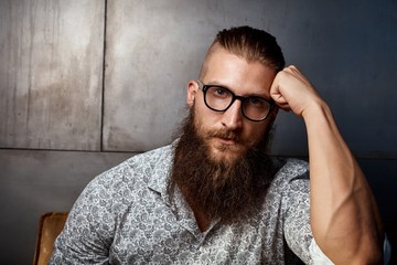 Obraz premium Portrait of young smart bearded man in glasses