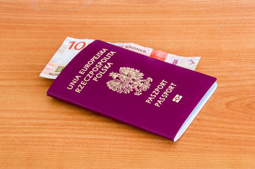 Polish biometric passport with 100 Norwegian krone banknote (NOK).