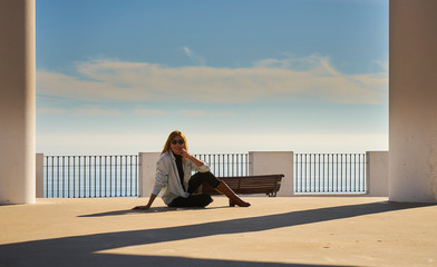 photo shoot blonde woman with columns and the sea in the background